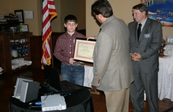 Surprised KF5NYQ Brandon gets his ARRL Certificate from K5UZ Dave and WD5BJT Charlie one of his ELmers.